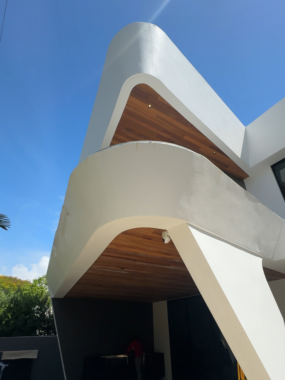 Wave House — folded cantilevered roofline with wood soffit, seen from below